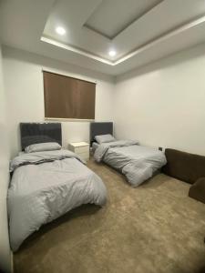 a bedroom with two beds and a couch at Talya Apartment in Mecca
