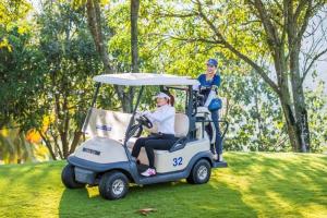 two people riding a golf cart in the grass at HAHA'S Villa in Binh Hai