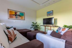 a living room with couches and a flat screen tv at Casa de temporada Âncora dos Sonhos Pirenópolis Goiás in Pirenópolis
