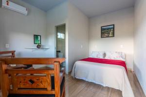 a small bedroom with a bed and a desk at Casa de temporada Âncora dos Sonhos Pirenópolis Goiás in Pirenópolis +49 photos