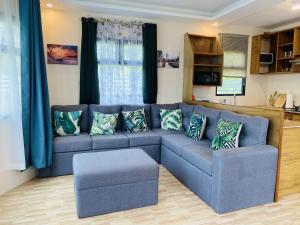 a living room with a blue couch with pillows at Birbeck Lodge in Bulusan