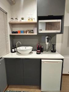 a kitchen counter with a sink and a microwave at Naby-My Stellenbosch Cottage in Stellenbosch