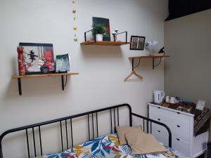 a bedroom with a bed and shelves on the wall at le prieuré reposant in Limetz