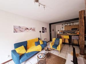 a living room with a blue couch and yellow pillows at Cosy atelier in Vierzon