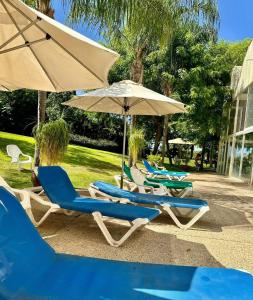 a group of lounge chairs and umbrellas at Pure Bliss Caesarea - אושר טהור בקיסריה in Caesarea
