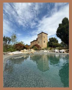 a large pool of water in front of a building at La Torre Masana in Vigostano