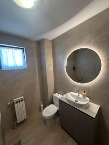 a bathroom with a toilet and a sink and a mirror at Grand apartman in Banja Luka