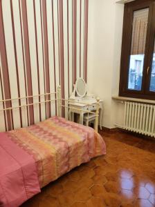 a bedroom with a bed and a table with a mirror at Maison Platone Jolie in Alessandria