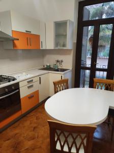 a kitchen with a white table and a table and chairs at Maison Platone Jolie in Alessandria