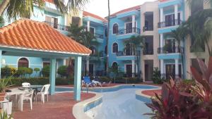 a hotel with a swimming pool in front of a building at 2BR Condo with Pool, Walk to Beach, Bvaro in Punta Cana