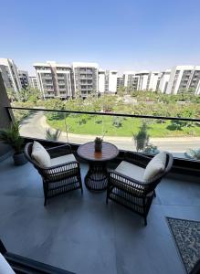 a patio with a table and chairs on a balcony at Modern apartment Madinaty in New cairo