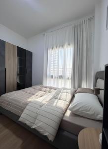 a large bed in a bedroom with a window at Modern apartment Madinaty in New cairo