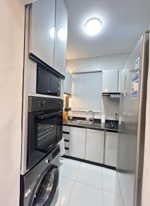 a kitchen with a washer and a stainless steel refrigerator at Modern apartment Madinaty in New cairo