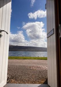 a door open to a view of a body of water at Para Handy Cottage, Inveraray in Inveraray
