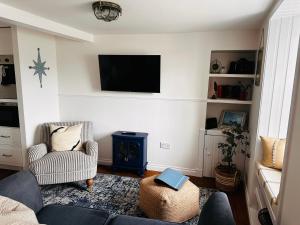 a living room with a couch and a tv on the wall at Para Handy Cottage, Inveraray in Inveraray