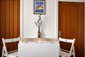 a table with two chairs and a vase on it at Para Handy Cottage, Inveraray in Inveraray +22 photos