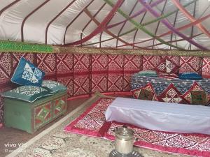 a room with a bed and mats in a yurt at Кольсайские озера, гостиница Айару in Kurmenty