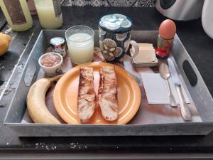 a tray with a plate of food with a sandwich and a banana at le prieuré reposant in Limetz
