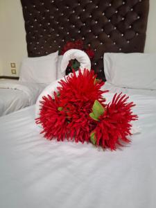 a bouquet of red flowers on a white bed at Dawn tawn velavet in Cairo