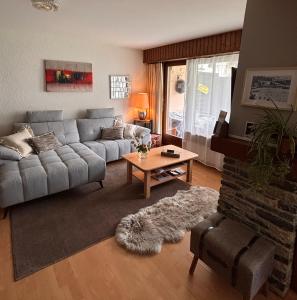 a living room with a couch and a table at Charmant appartement hyper central, idéal pour couple ou petite famille, parking couvert in Crans-Montana