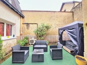 a patio with chairs and a table and a tent at Cosy atelier in Vierzon