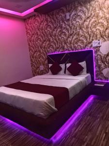 a bedroom with a bed with a purple led lighting at hotel shree shyam palace in Ujjain