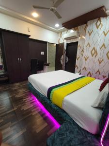 a bedroom with a large bed with neon lights at hotel shree shyam palace in Ujjain +7 photos