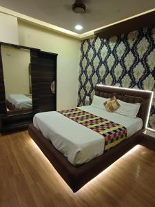 a bedroom with a large bed and a mirror at hotel shree shyam palace in Ujjain