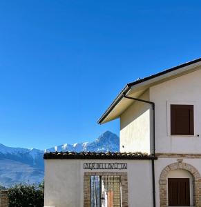 a building with a sign on it with mountains in the background at Agriturismo Bellavista - Ronzano in Ronzano