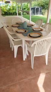 a white table and chairs with plates on it at Villa Tilo in Sainte-Anne