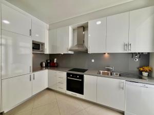 a white kitchen with white cabinets and a sink at Lisboa Arroios Apartment in Lisbon