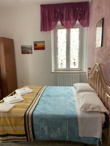 a bedroom with a large bed with a window at Le camere del Baldo parcheggio gratuito in centro storico in Peschiera del Garda