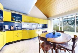 a kitchen with a wooden table and yellow cabinets at BluVilla in Malvaglia