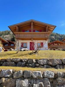 a house on a hill with a stone wall at Ferienhaus Gollbichl in Sachrang