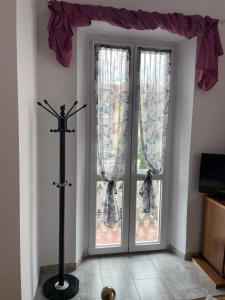 a room with doors with curtains and a window at Le camere del Baldo parcheggio gratuito in centro storico in Peschiera del Garda