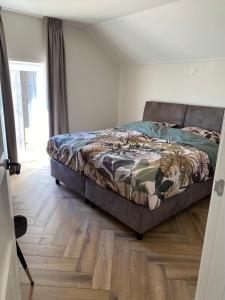 a bedroom with a bed and a wooden floor at Vakantiewoning Op de Woerd in Aalten