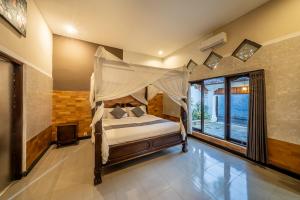 a bedroom with a bed with a canopy at Villa Papat Seminyak in Seminyak