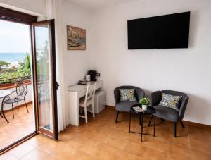 a room with two chairs and a table and a television at Stella Marina Sea & Sun in Cefalù