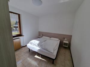 a bedroom with a bed and a window at Casa Pineta in Ledro