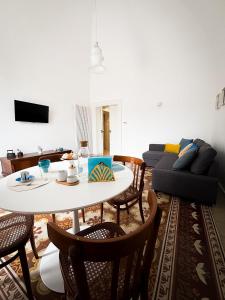 a living room with a table and chairs and a couch at Dimora Veneziani in Bisceglie