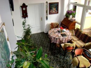 a living room with a table and a clock at Pension Casa Leone in Timişoara
