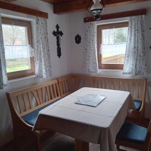 a dining room with a table and two windows at Chata Gerlinda in Kašperské Hory +15 photos