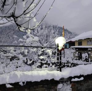 a snow covered fence with a light on top of it at Hotel Veerjeet Resorts in Doda