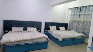 a bedroom with two beds and a curtain at Hotel Veerjeet Resorts in Doda