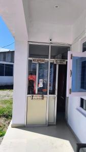 an open door of a white building with a inspection sign at Hotel Veerjeet Resorts in Doda +5 photos