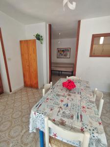 a dining room table with a red flower on it at Giglio Gold in Giglio Porto