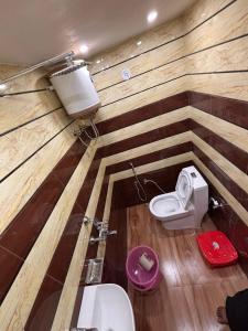 a bathroom with a toilet in a wooden wall at Suryavanshi Guest House in Ayodhya