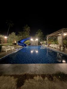 a swimming pool at night with chairs and lights at Sekepeng Penarek in Kampung Penarik