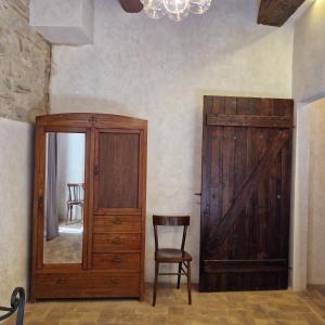 a room with a door and a chair and a mirror at Domus Calzolari in Gubbio