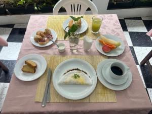 a table with plates of food on a pink table at Pousada Shamah - Morro de São Paulo in Morro de São Paulo